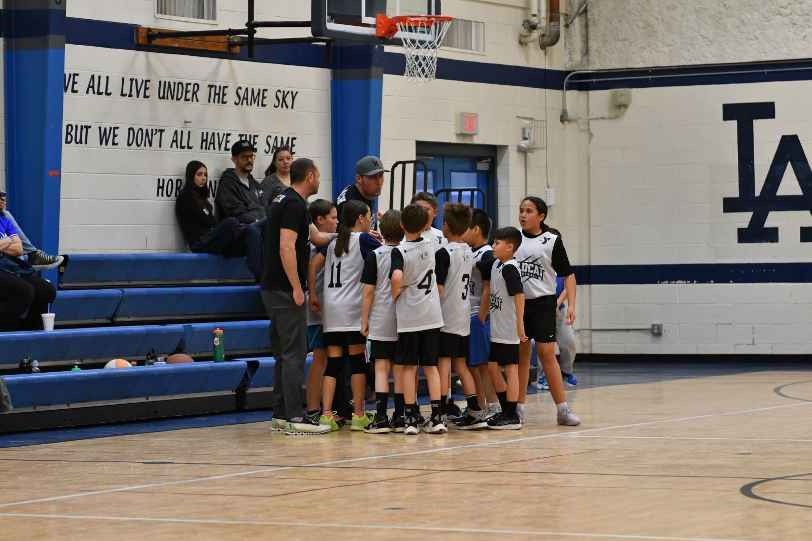 Youth sports players huddling with their coach