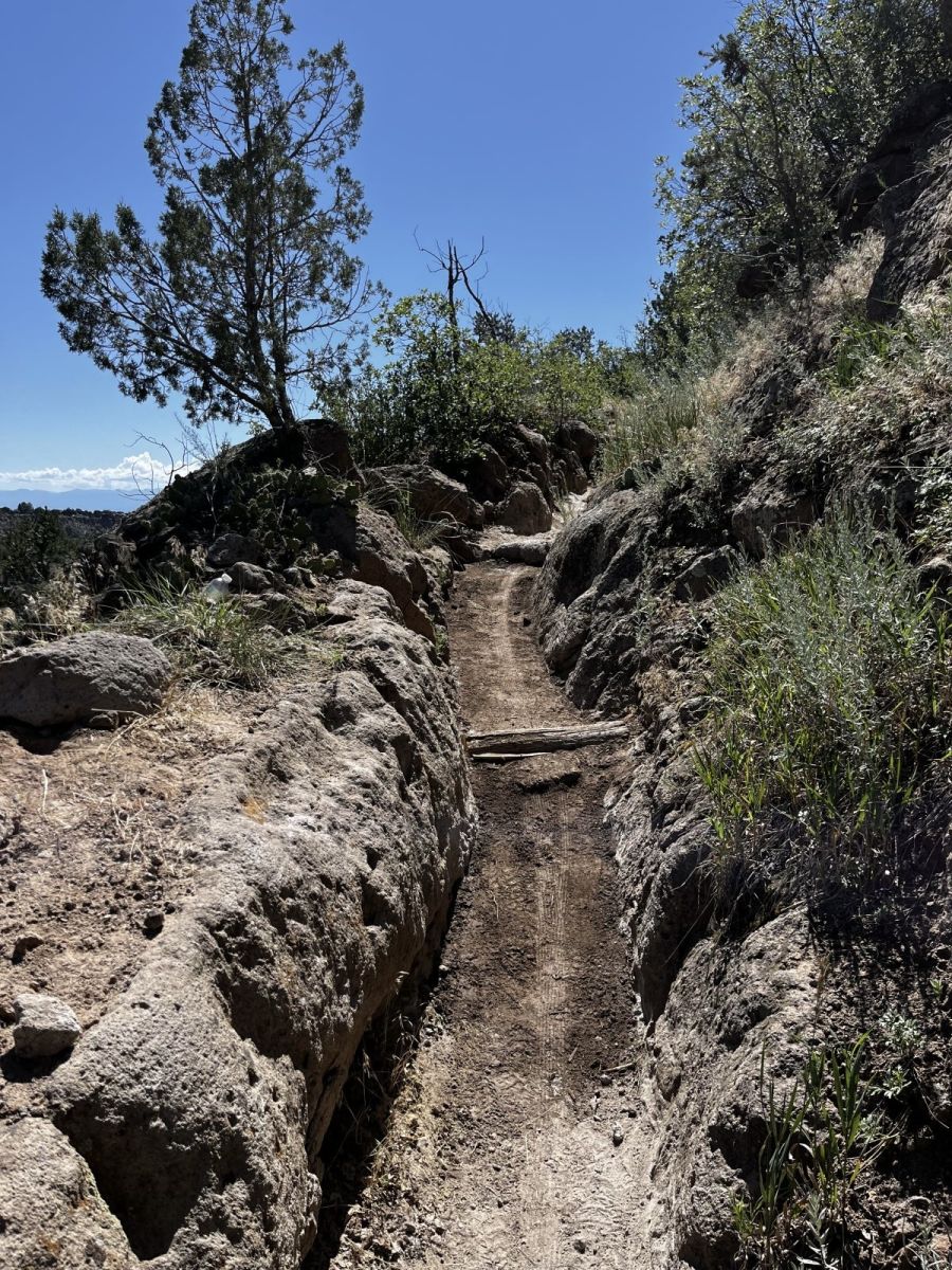 Finished trail cut through rock with blue sky above